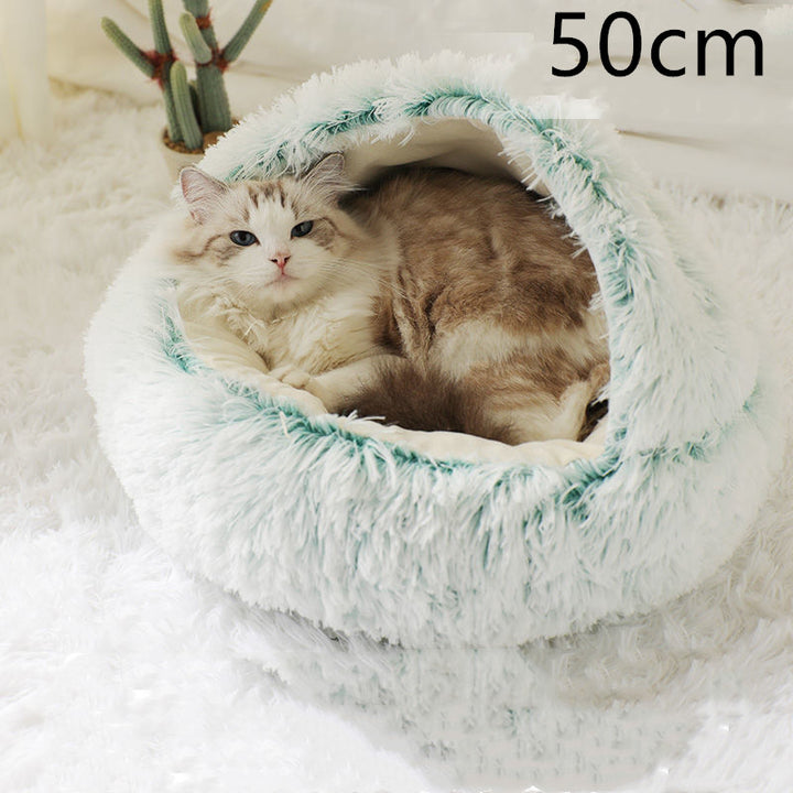 Kot śpiący w okrągłym pluszowym legowisku z odchylonym kapturem
